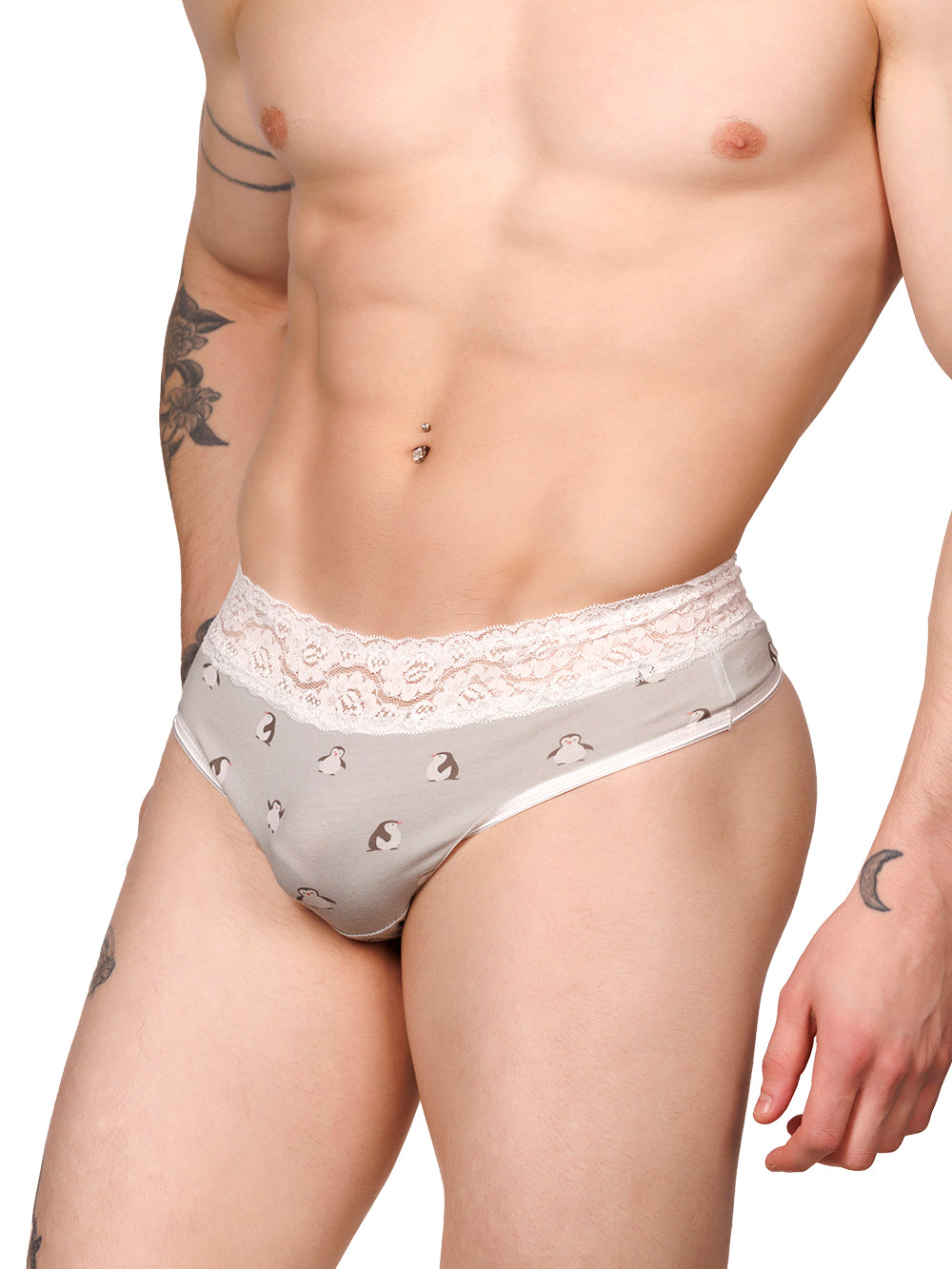 Side view of a male model wearing grey XDress thong panties with a white lace waistband and penguin print