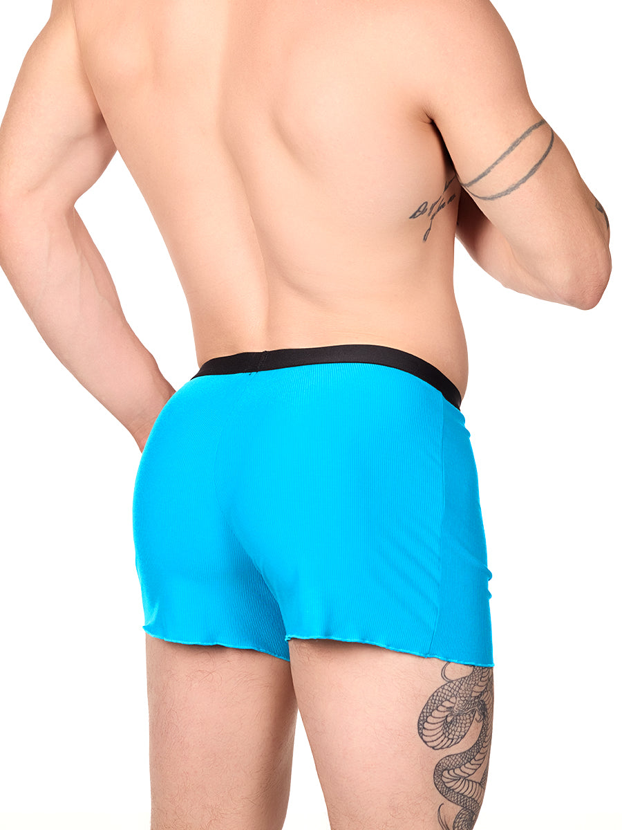 Side view of a man wearing turquoise XDress lounge shorts with black waistband