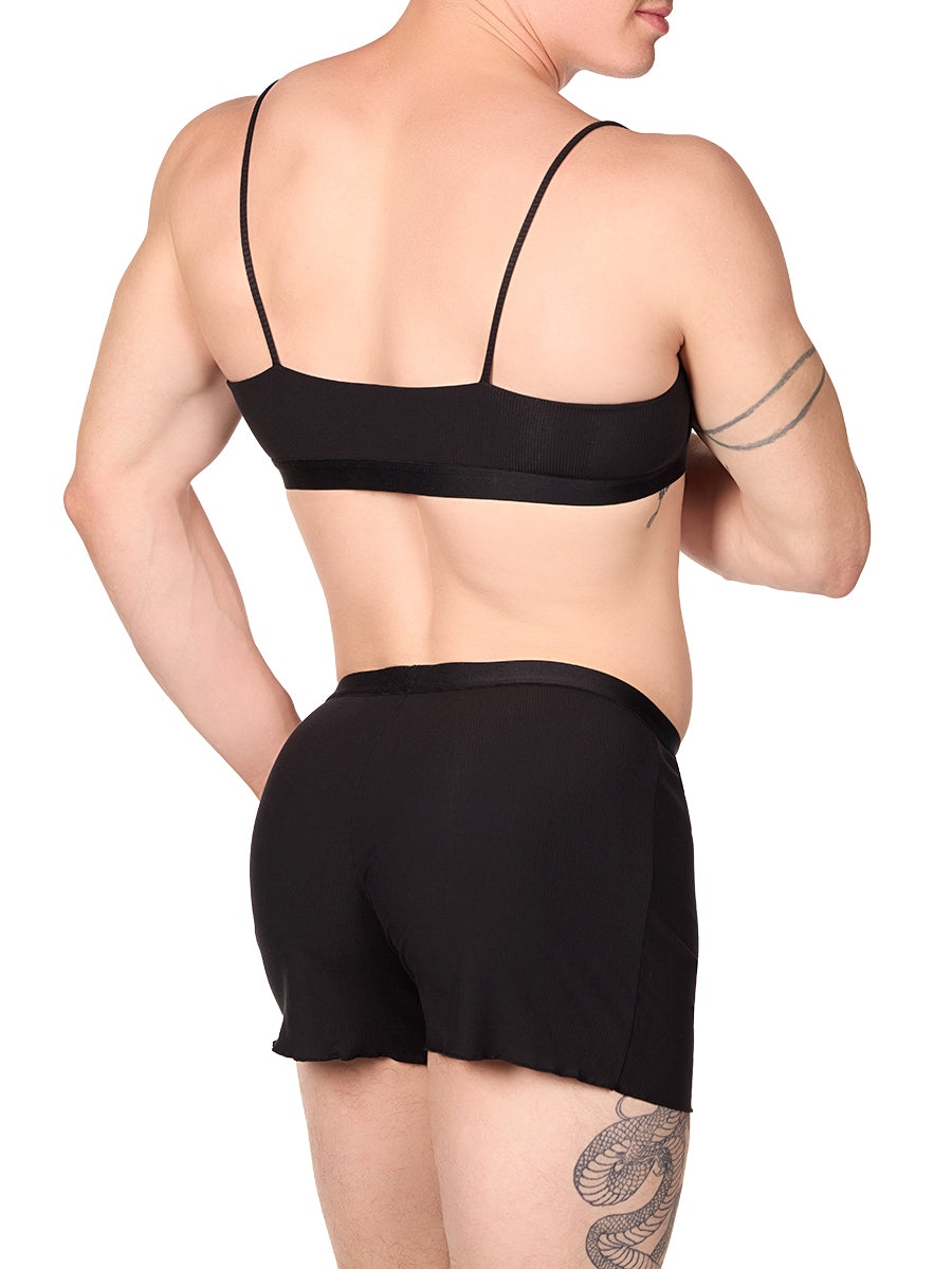 Side view of a man wearing a black XDress bralette with matching shorts