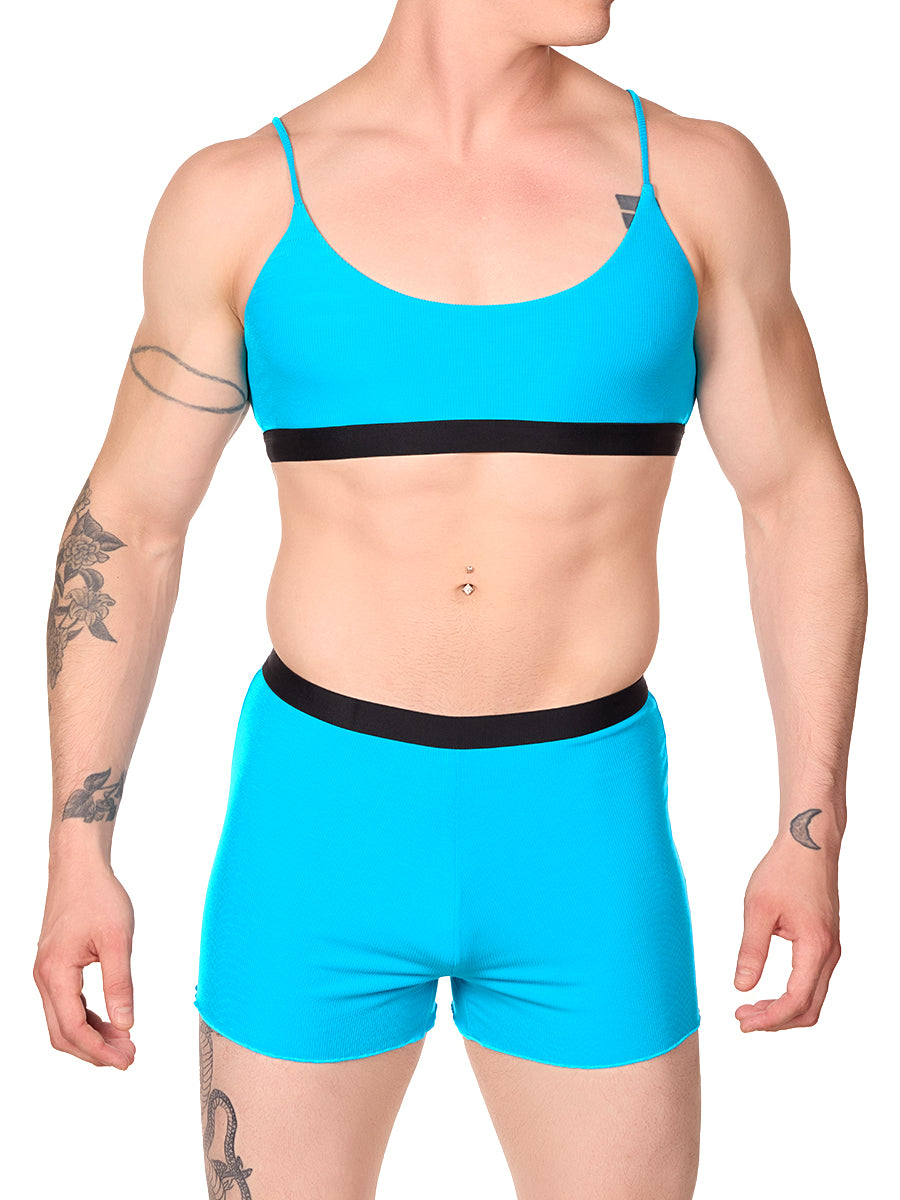 Front view of a man wearing a turquoise XDress bralette with matching shorts