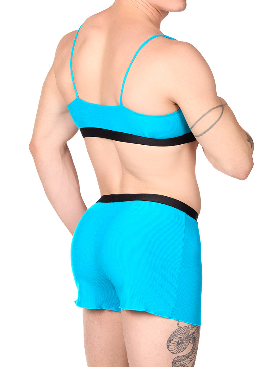 Side view of a man wearing a turquoise XDress bralette with matching shorts