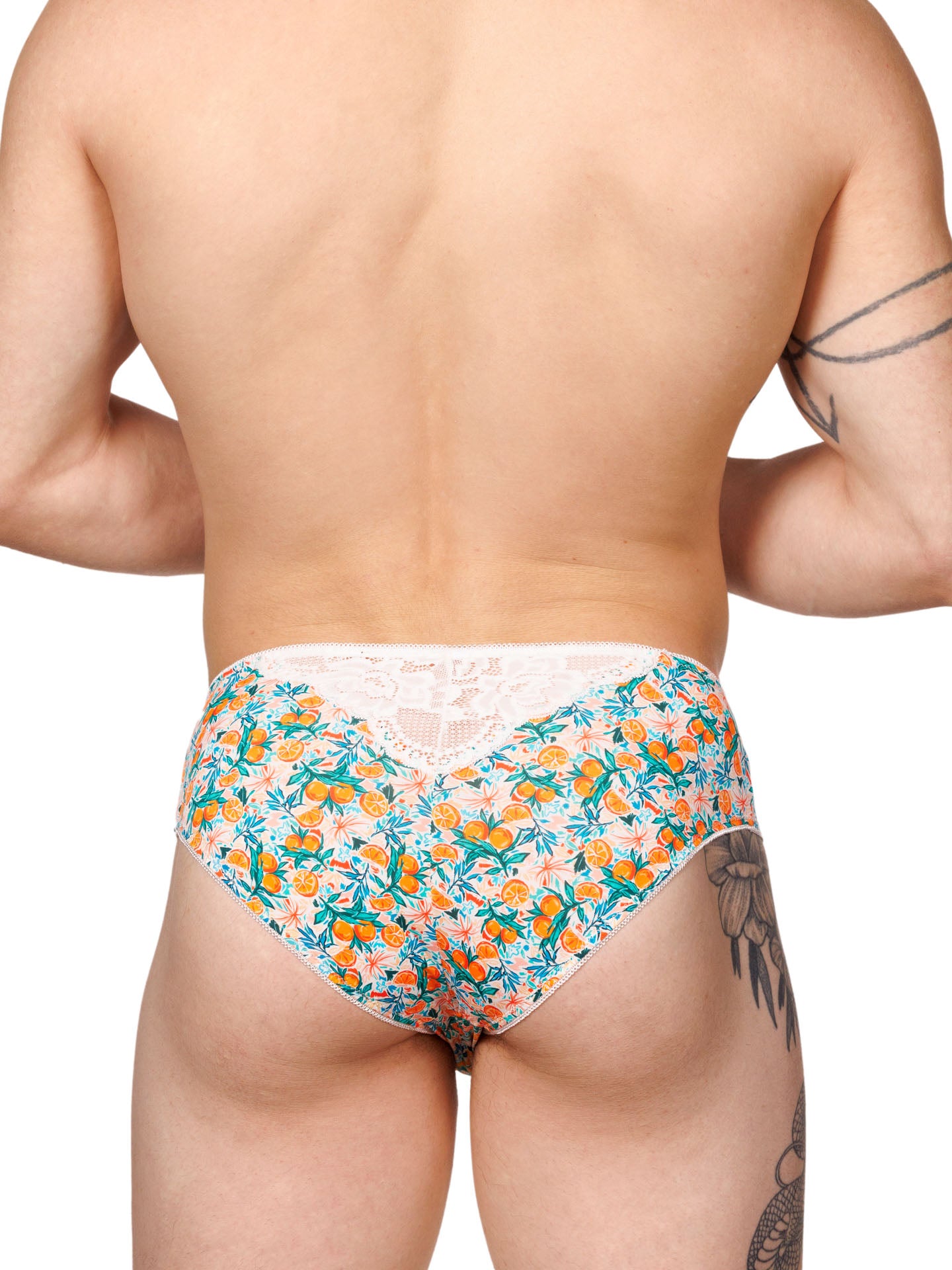 Rear view of a male model wearing XDress men's panties with a vibrant orange blossom pattern.