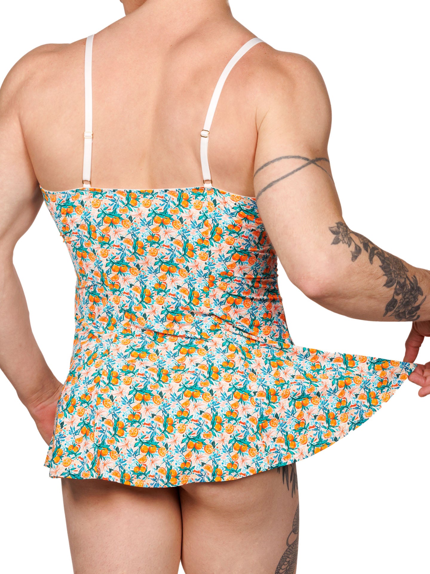 Rear view of a male model wearing an XDress babydoll with a vibrant orange blossom pattern.