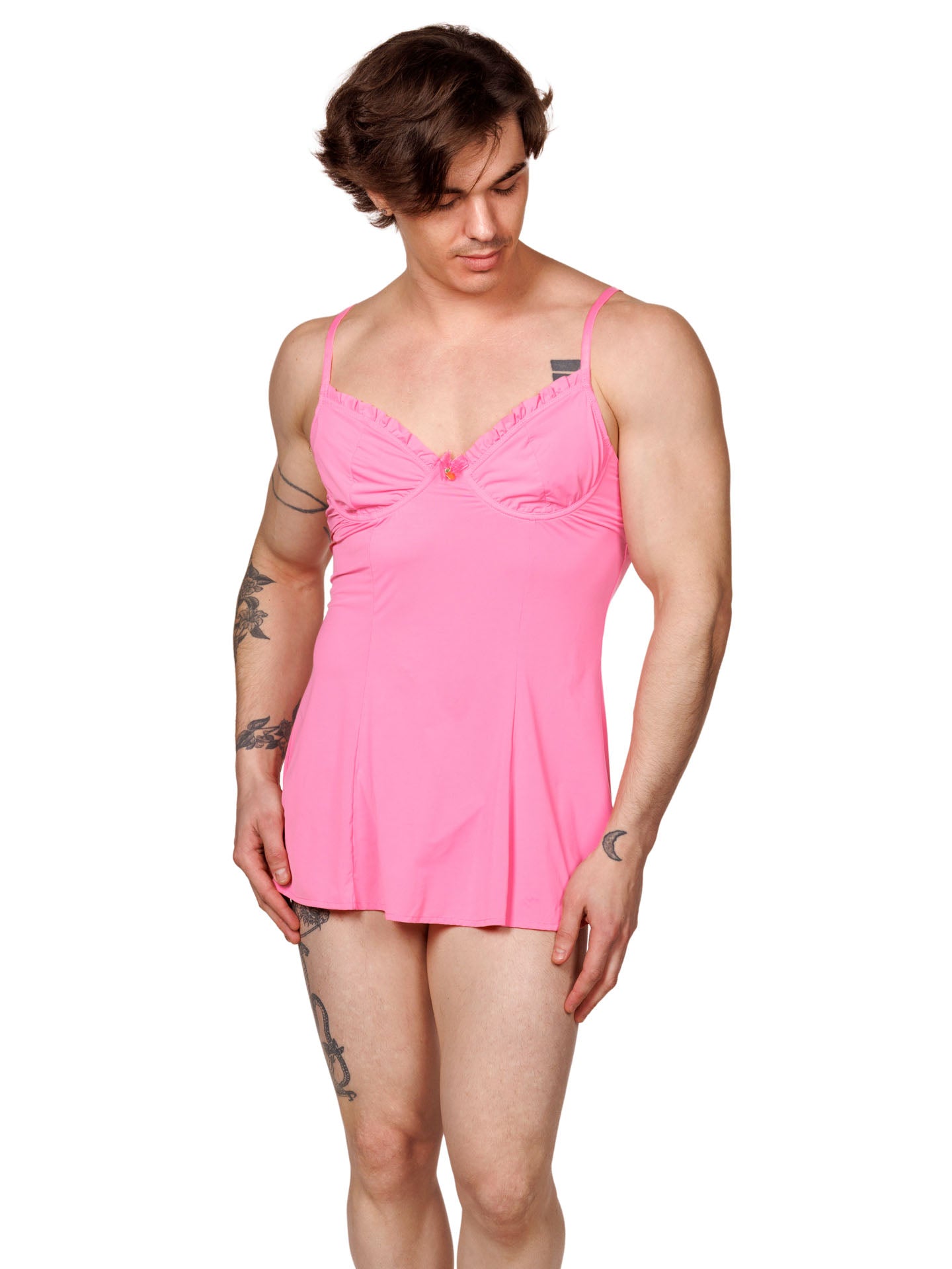 Front view of a male model wearing a pink men's babydoll with seamed underwire cups, adjustable shoulder straps and a flowing hem.