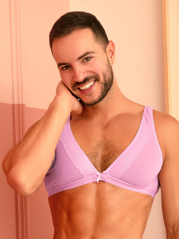 A man wearing a matching purple bra and panty set
