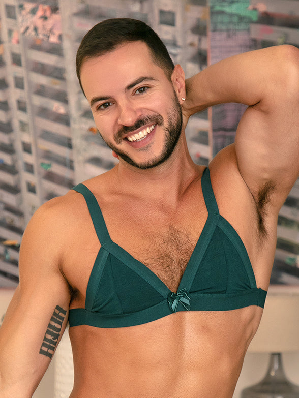 A male model posing in a matching green bra and panty set.