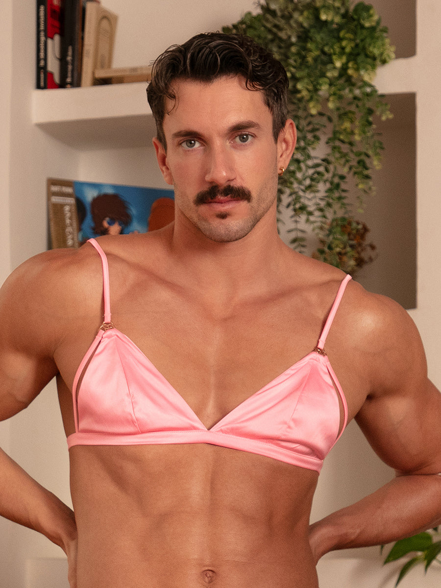 Front view of a man wearing a pink satin bra.