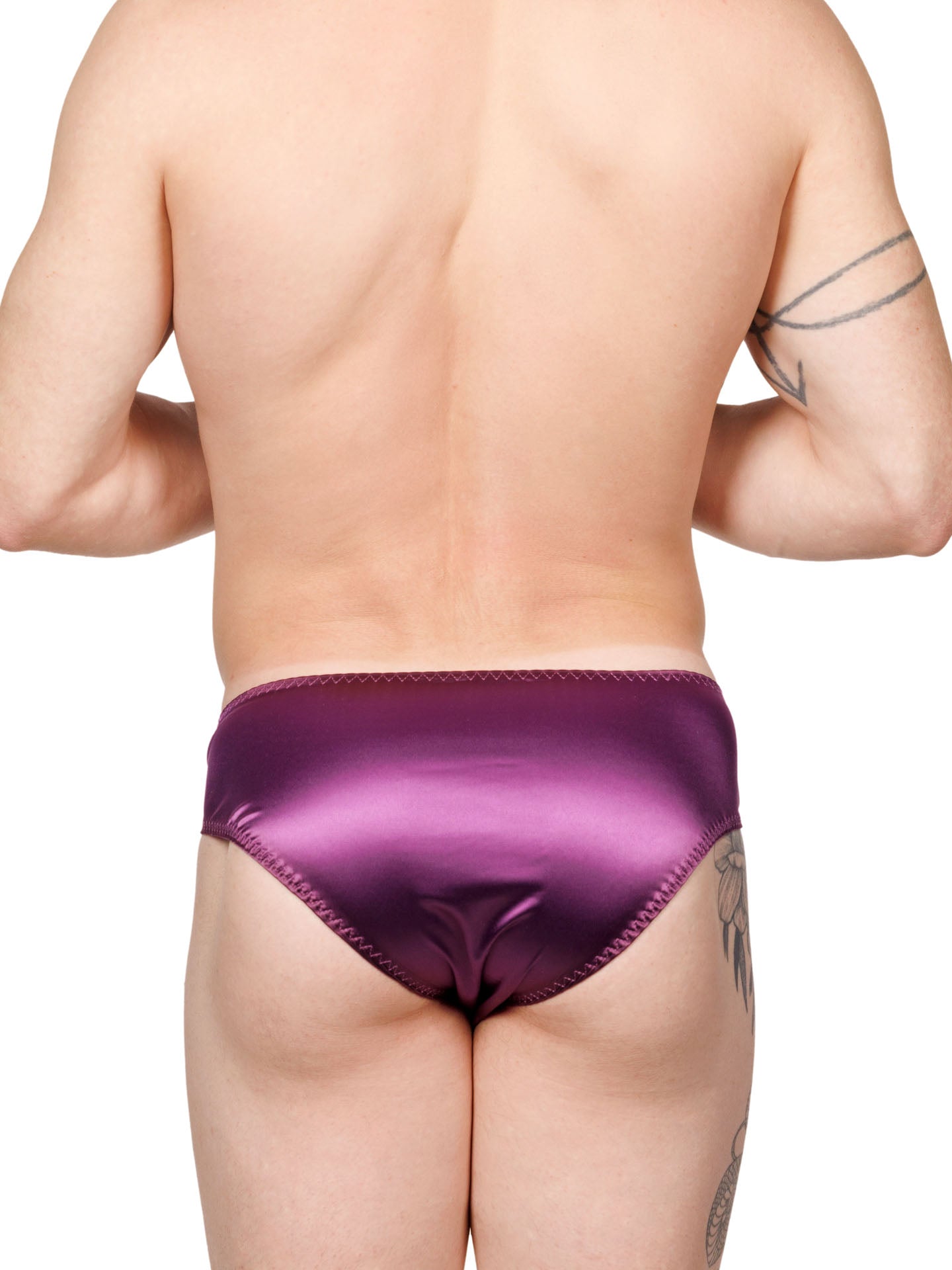 Back view of a male model wearing purple XDress panties with matching bows