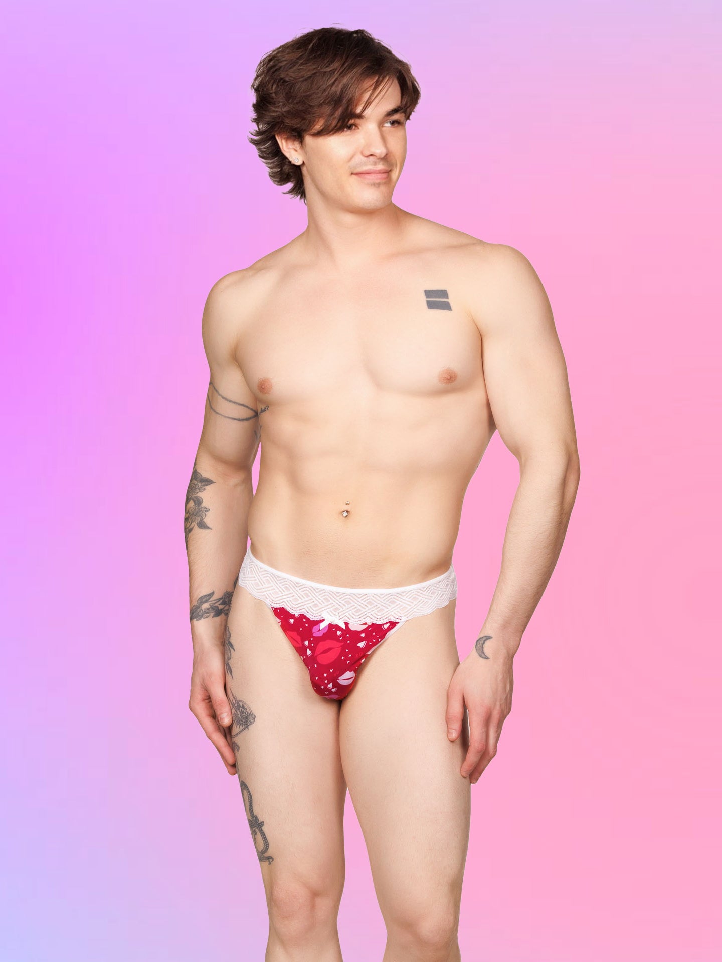 Front view of a male model wearing an XDress red men's thong with lipstick kisses pattern and lace waistband