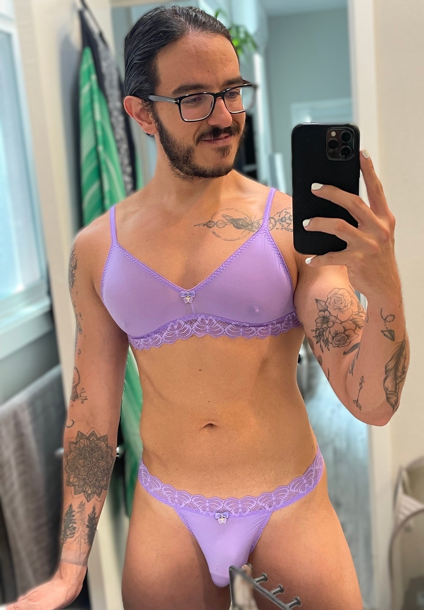 Person wearing a purple lingerie set taking a mirror selfie.