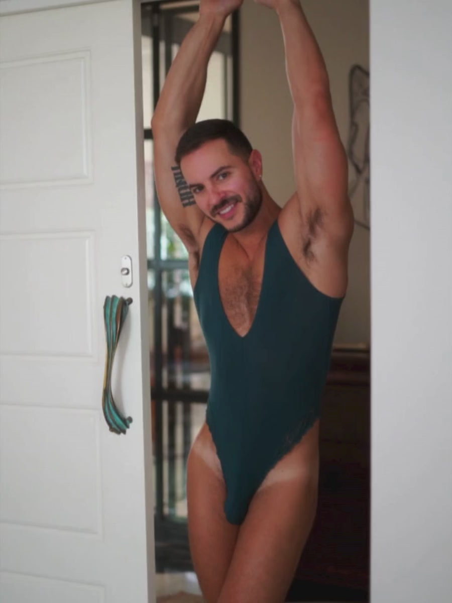 Video of a man wearing teal lingerie, posing in a doorway.